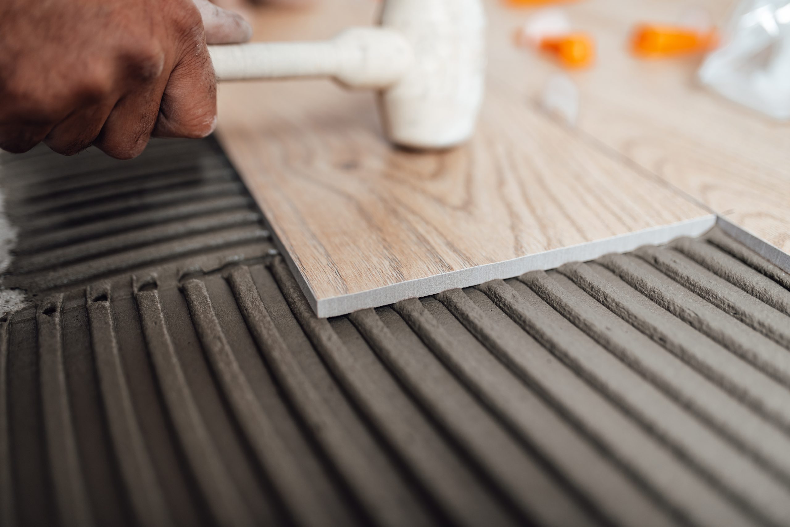 Flooring and tiling. Professional tiler placing floor tiles on a